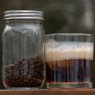 Boss Coffee cocktail next to a jar of coffee beans.